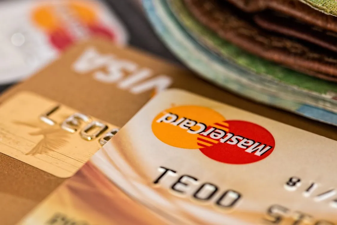 Premium credit cards fanned out on a desk beside a statement and a calculator